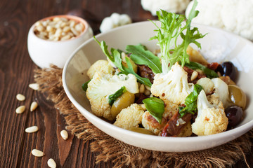 Roasted cauliflower salad with olives, tomatoes, nuts and basil