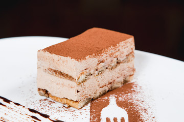 Delicious world famous Tiramisu cake on a white plate with decoration