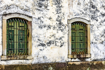 Old and aged historic wooden church windows with stone frame and grids in the city of Ouro Preto,...