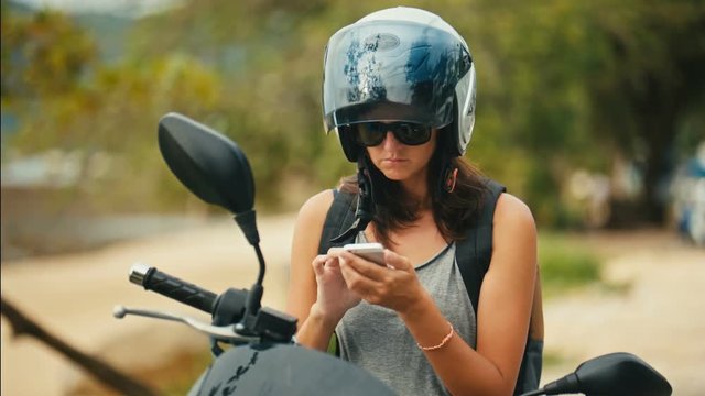 Portrait of woman biker using the map application on the smartphone