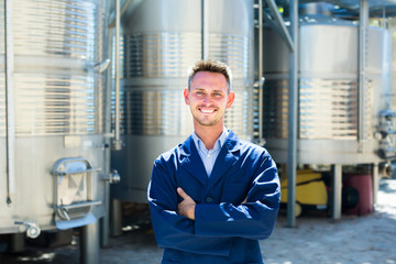 Portrait of positive man worker on wine factory