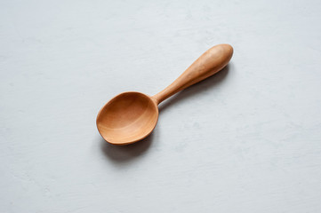 A wooden spoon handmade lies on a gray background.
