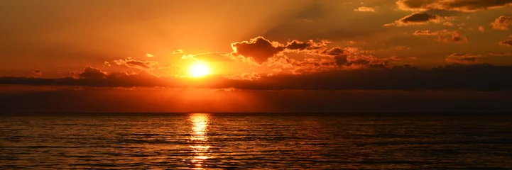 Wandaufkleber wunderschöner orangefarbener Sonnenuntergang auf der ruhigen See © WeźTylkoSpójrz