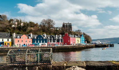 Lobster trap on a quay wall with the colorful town of Tobermory in the background