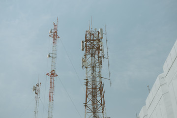 Cell phone tower rises against a blue sky, Used to transmit telephony signal.