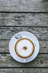 Cup of coffee on wooden table, top view