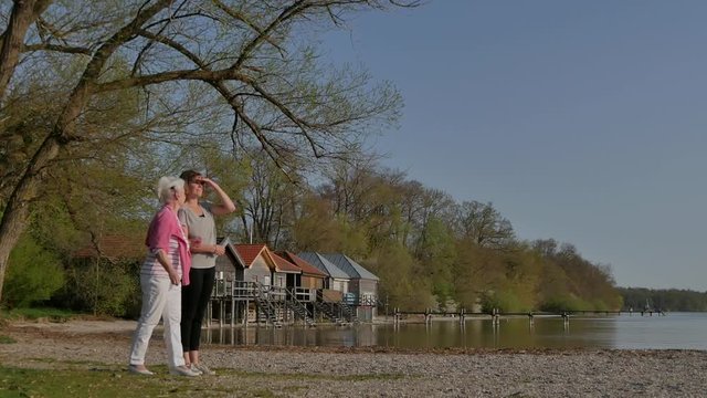 Seniorin mit junger Frau am See