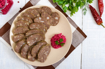 Home made dietary sausage from the liver on a white wooden table. Sausage cut into pieces on a...