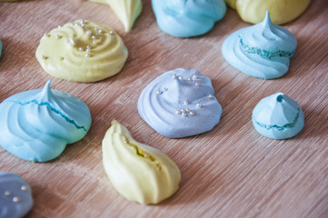 Obraz na płótnie Canvas trendy french cookies flat lay. meringue top view background. sea shell dessert. green and blue color candy. whipped egg white sweets. marine mood with tasty meringues. silver luxury sprinkles pearl.