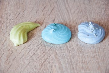 sea shell dessert. trendy french cookies flat lay. meringue top view background. green and blue color candy. sumer vacation on beach. marine mood with tasty meringues. silver luxury sprinkles pearl.