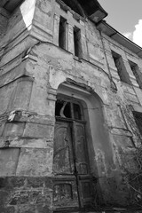 Fototapeta na wymiar old abandoned mansion with half-painted plaster in black and white tones