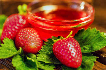 Fresh strawberries with leaves and jam close