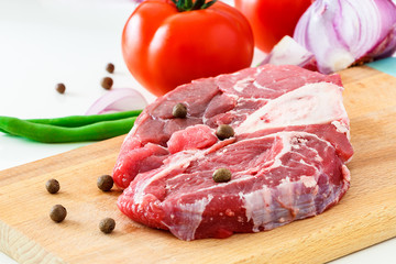 Raw meat beef steak and vegetable on wooden cutting board. Close up.