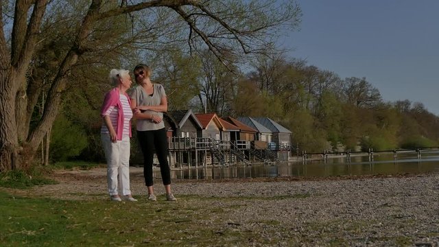 Seniorin mit junger Frau am See im Fr&uuml;hling