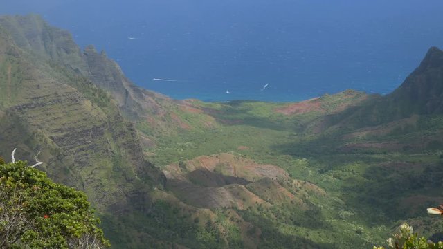 Panning view of the Kalalau Valley, the largest valley on Kauai's Na Pali coast. Boats in the distant ocean add a sense of scale to the view.