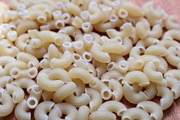 Raw pasta. Macro. Spilled on the table pasta. Background