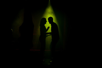 Silhouettes of guy and girl in club