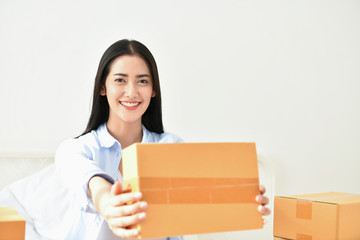 Fototapeta na wymiar Sme business concept. Young people are packing their packages.Delivery business Small and Medium Enterprise (SMEs). Young woman is working in the house.Young Owner Start up for Business Online.