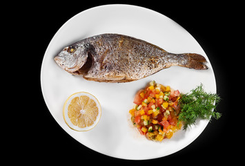 fish grill dish baked whole grilled on a plate with vegetables and lemon on top for the menu
