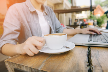 Beautiful hipster woman using laptop at cafe