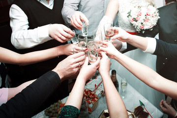 A lot of hands are holding glasses in the center, a wedding.