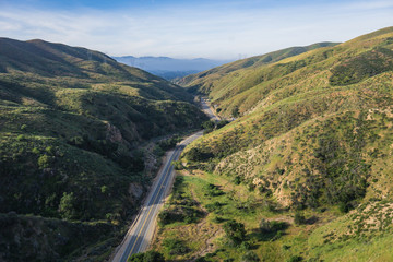 Fototapeta na wymiar Road leads along the bottom of a canyon in southern California's Los Angeles County.
