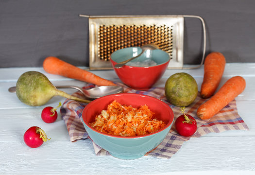 Fresh salad with root green radish and carrot. Spoon and grater