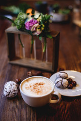 Cappuccino, cookies and flowers.