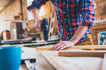 Carpenter At Work Using  Hand Drill