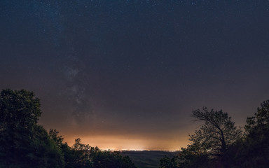 Fototapeta na wymiar Milky Way galaxy over the huge town. Milky Way galaxy over the Belgrade, view from mountain Avala, Serbia, Europe. The night sky is astronomically accurate.