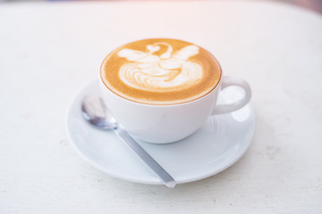 A Cup of hot latte art coffee on wooden table