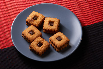 Chocolate sand chip cookies stacked up on a plate, ready to be served on blue plate