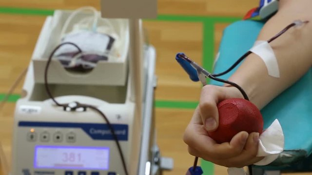 Hand of blood donator with blood colection mixer