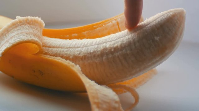 Woman sexually touching with a finger of purified banana, macro close up view