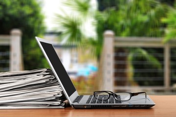 Laptop and black glasses  on table