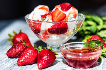 Strawberry ice cream with mint in bowl and jam