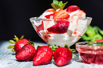 Strawberry ice cream with mint in bowl and jam