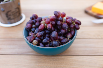 Bowl of red grapes on picnic table