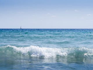ocean waves with sailing ship on the horizon