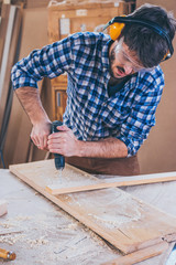 Carpenter At Work Using  Hand Drill