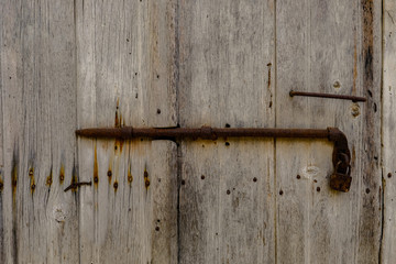 Close up of an old wooden door with rusty latch.