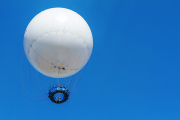 white balloon flies on a background of blue sky