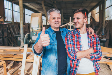 Carpenters standing proud in front of a workshop, family business