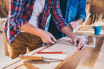 Close up of Carpenters Measuring A Wooden Plank