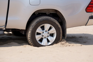 Fototapeta na wymiar Rear wheels of a truck stuck in sand