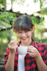 asian beautiful woman drinking hot coffee or tea in the green garden