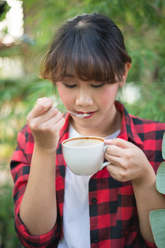 Asian Beautiful Woman Drinking Hot Coffee Or Tea In The Green Garden