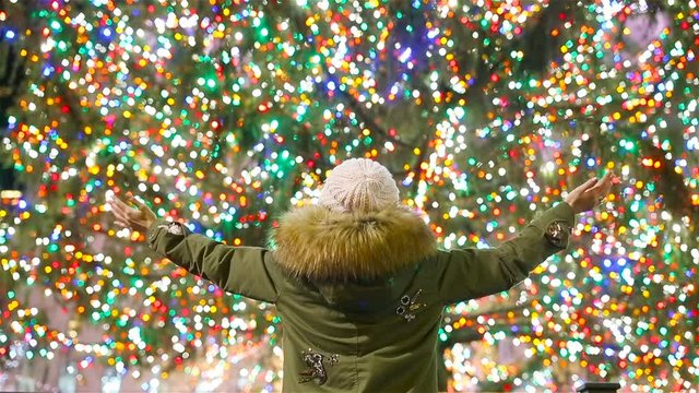 Happy girl on the background of the Rockefeller Christmas tree in New York