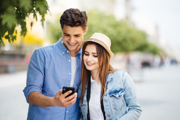 Couple of tourists consulting smartphone gps in the street searching locations in new city