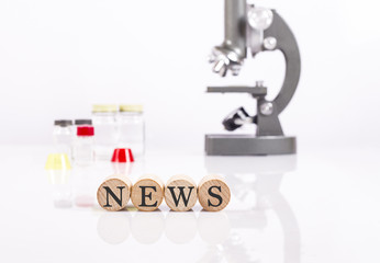writing news front of microscope and test tubes for health and science news